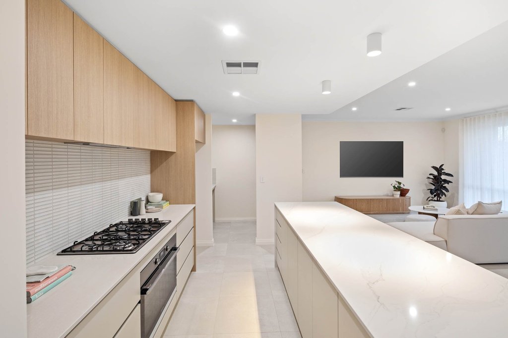 The Magnolia display home: cooktop run and island with the living room beyond